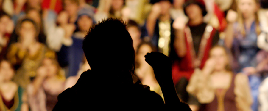 Silhouetted soloist singing in front of a church choir